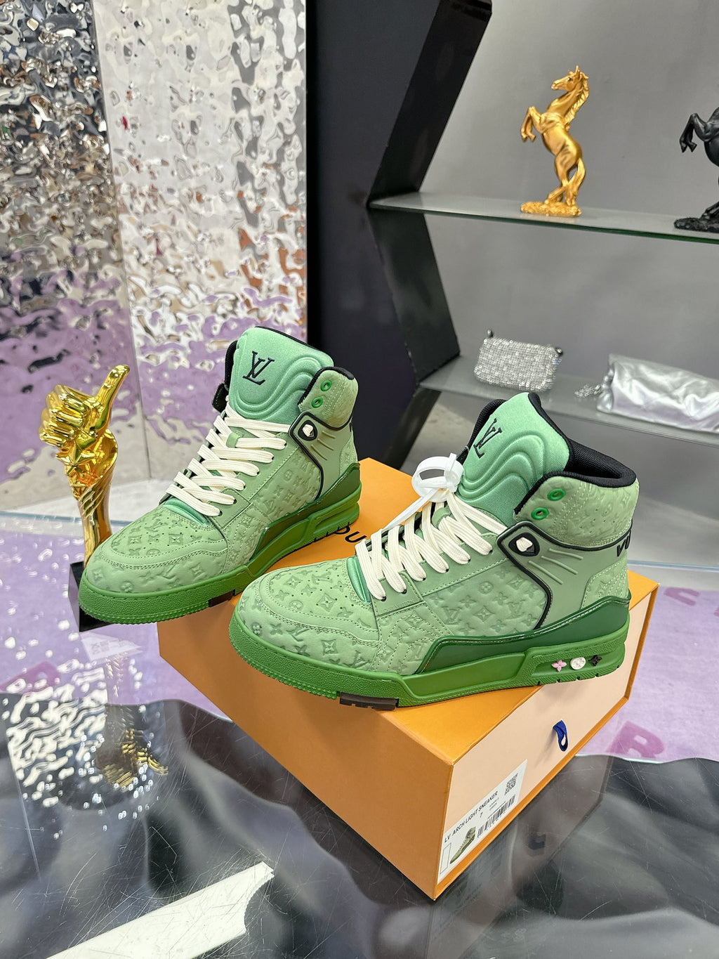 Pair of green Louis Vuitton high-top sneakers with white laces on display box