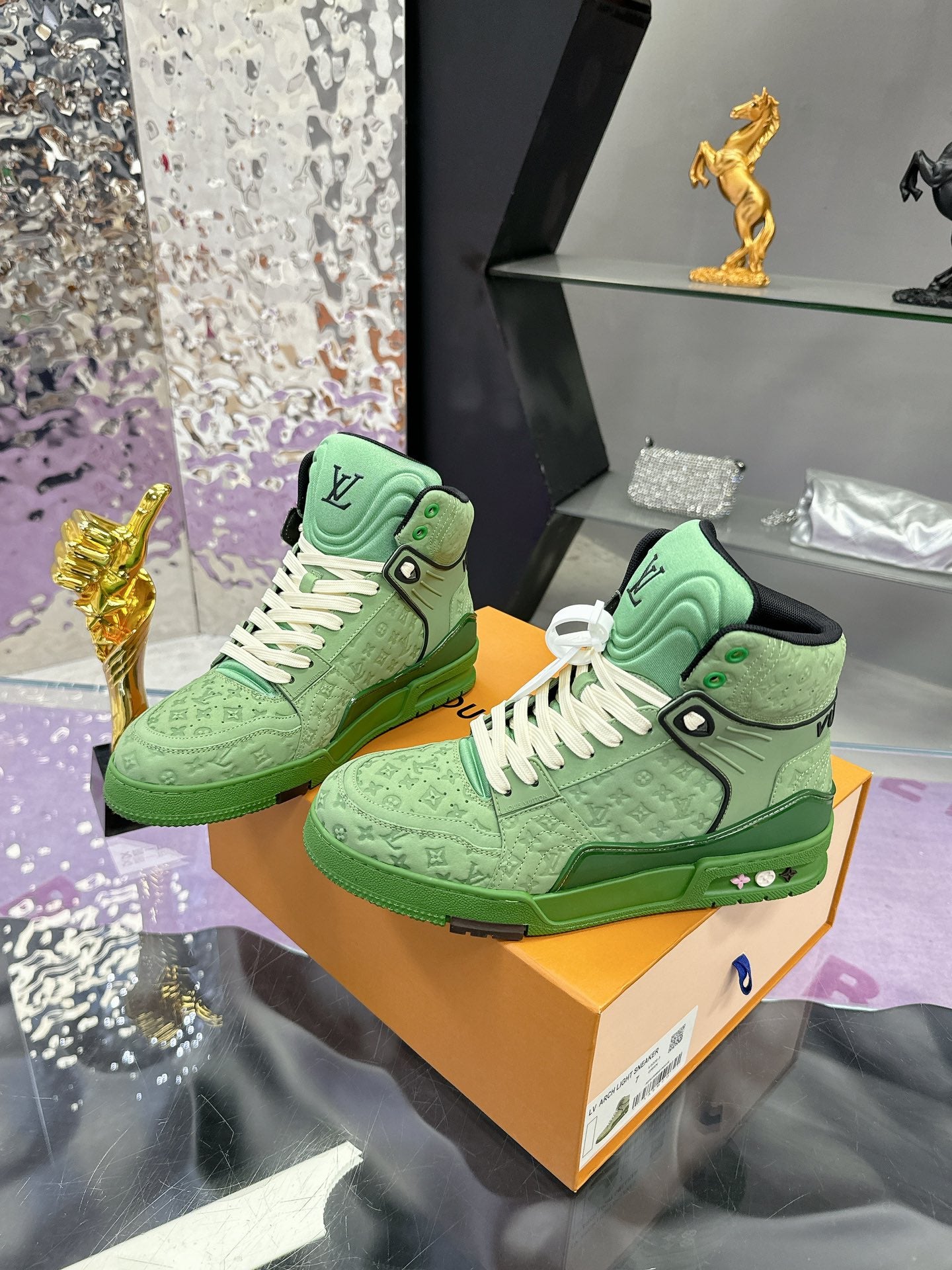 Pair of green Louis Vuitton high-top sneakers with white laces on display box