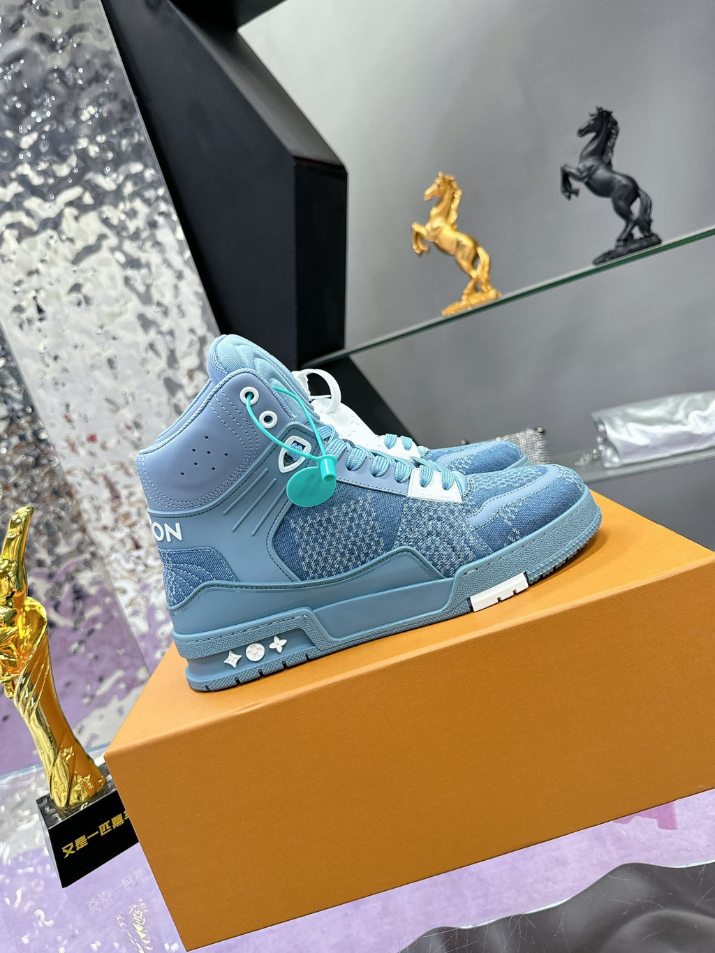 Light blue high-top sneaker with side logo, teal lace accents and textured upper