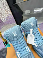 Close view of light blue high-top sneakers with LV-style side logos and hanging tags