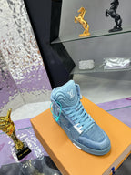 Single light blue high-top sneaker on orange box with teal lace detail and side emblem