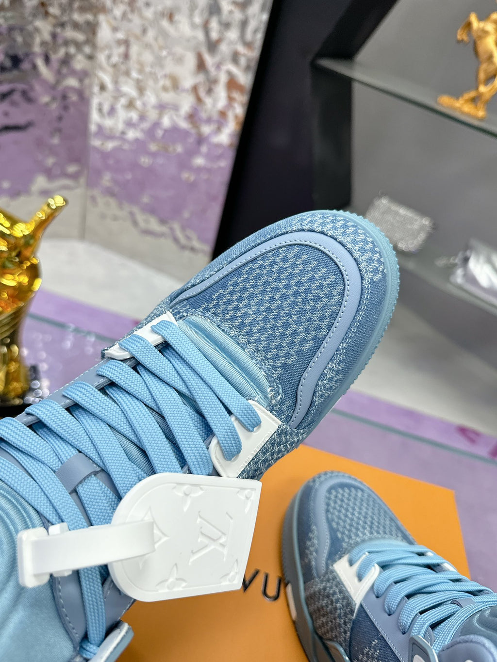 Light blue high-top sneaker heel and upper close-up with white branded lace tag