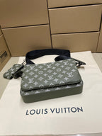 Green monogram crossbody bag top view with front zipper and navy shoulder strap