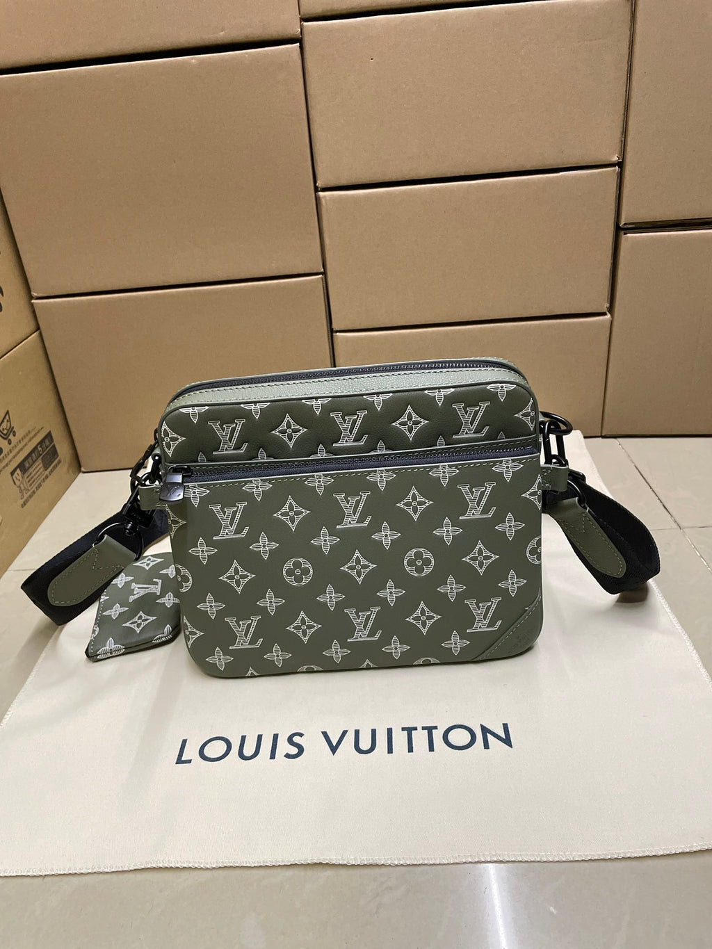 Green monogram crossbody bag front view with zipper and side strap attachments