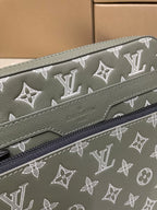 Green monogram crossbody bag side close-up with zipper track and stitched trim