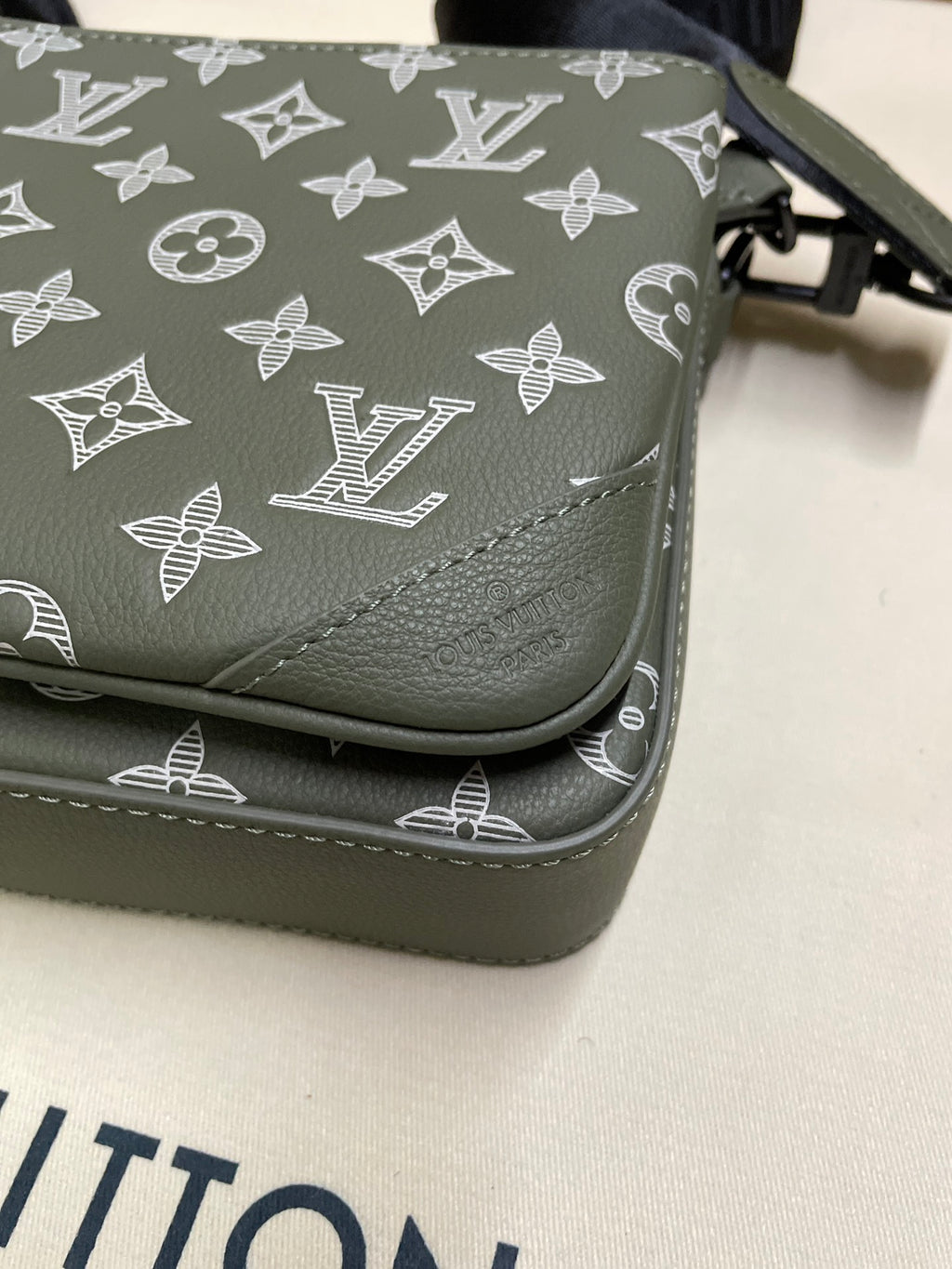 Louis Vuitton bag close-up of corner stitching and monogram print in dark olive