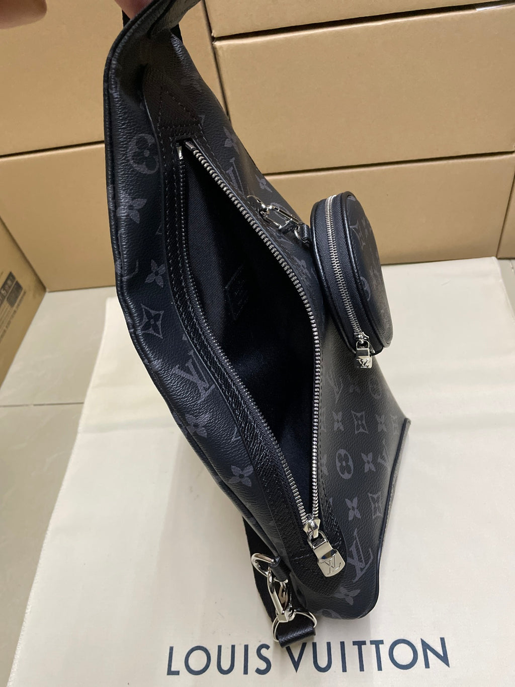 Dark monogram sling bag with side zip and adjustable crossbody strap