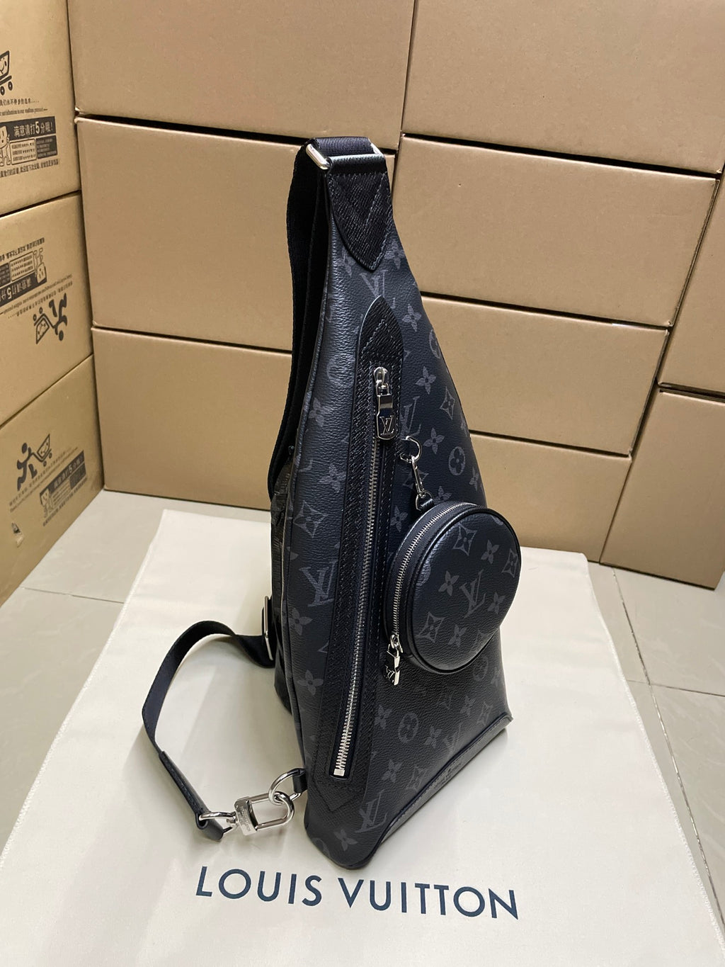 Dark monogram sling bag with zip-front and attached round mini pouch