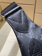 Pebbled leather flap detail on dark monogram crossbody bag