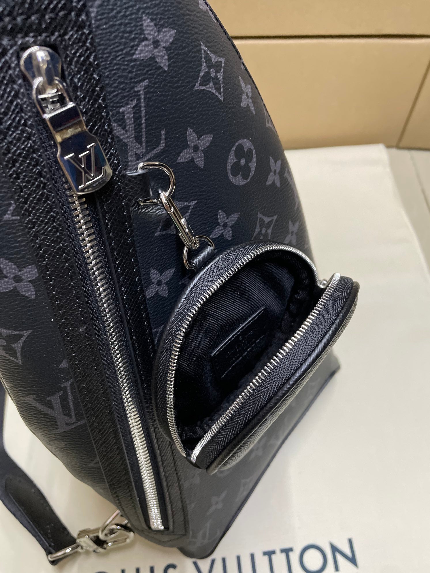 Dark monogram sling bag front zipper and zip pocket detail