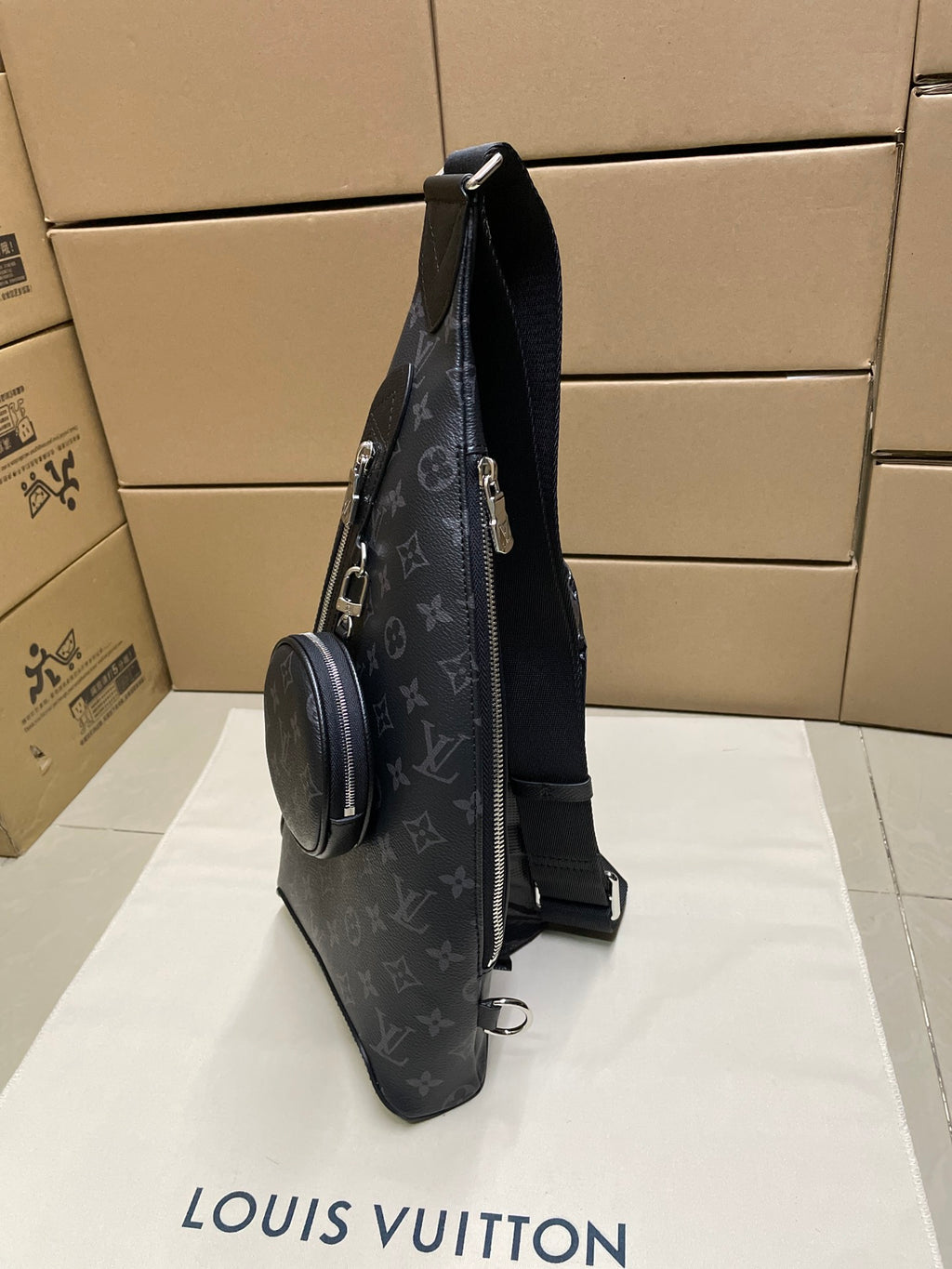 Dark monogram sling bag with web strap and attached round mini pouch