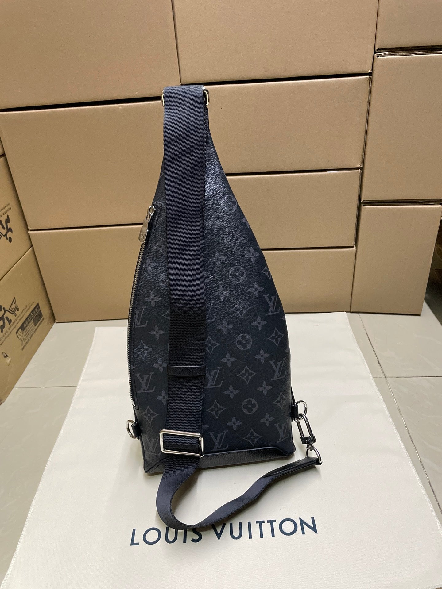 Dark monogram sling bag with adjustable strap and metal buckle