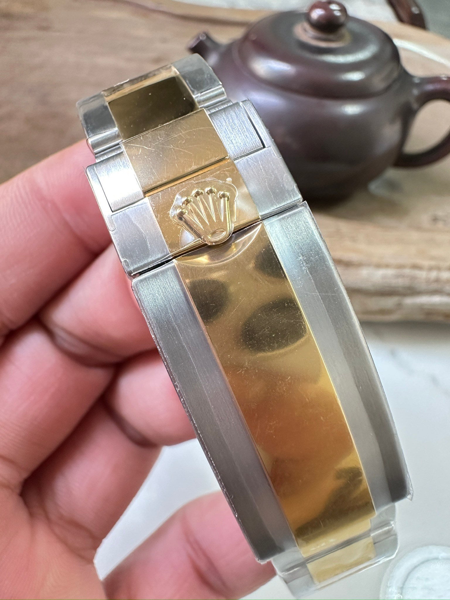 Rolex Submariner clasp with gold crown emblem on two-tone metal bracelet