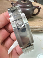 Rolex Daytona watch case and bracelet clasp, polished stainless metal, crown visible
