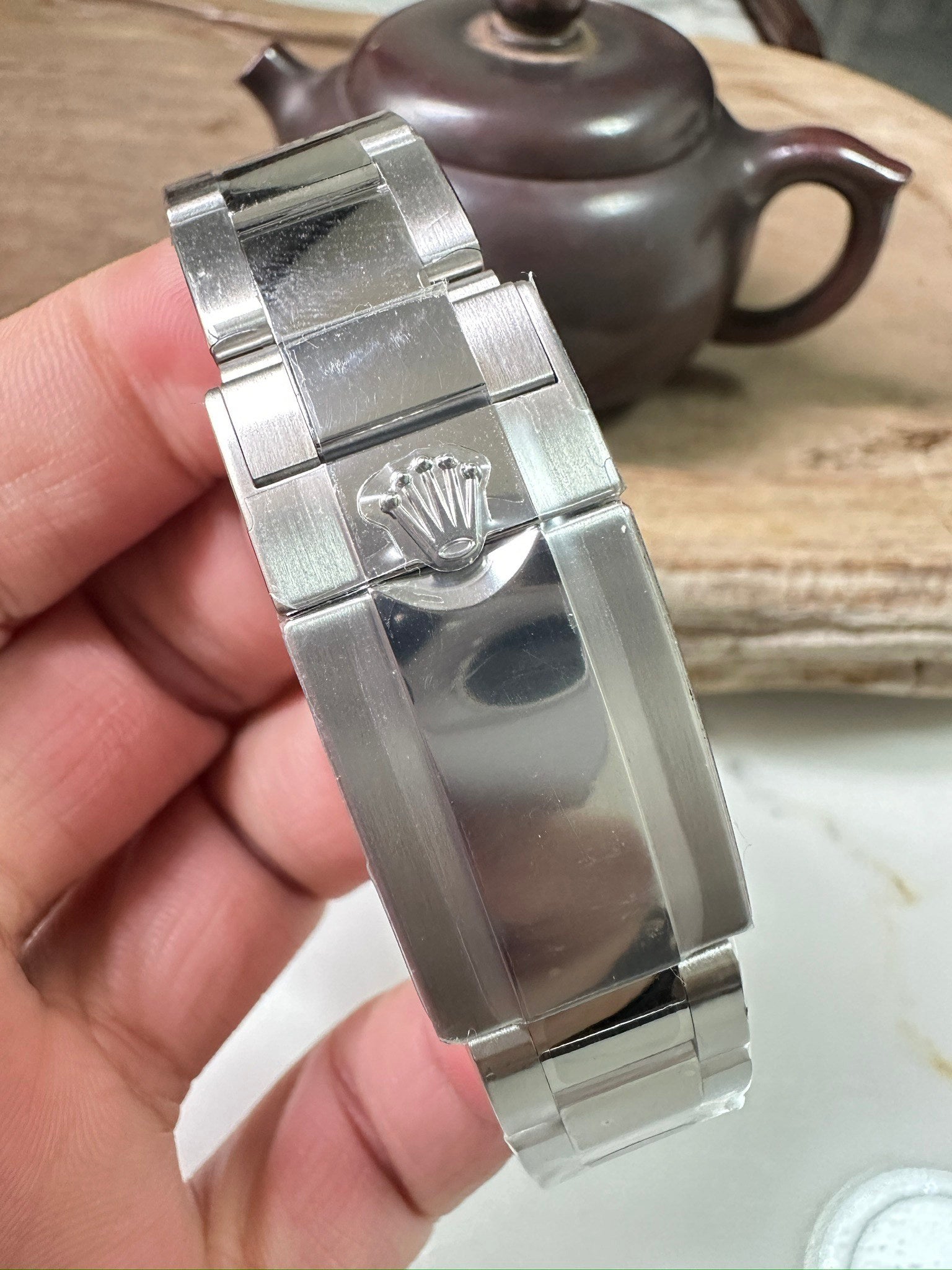Rolex Daytona watch case and bracelet clasp, polished stainless metal, crown visible