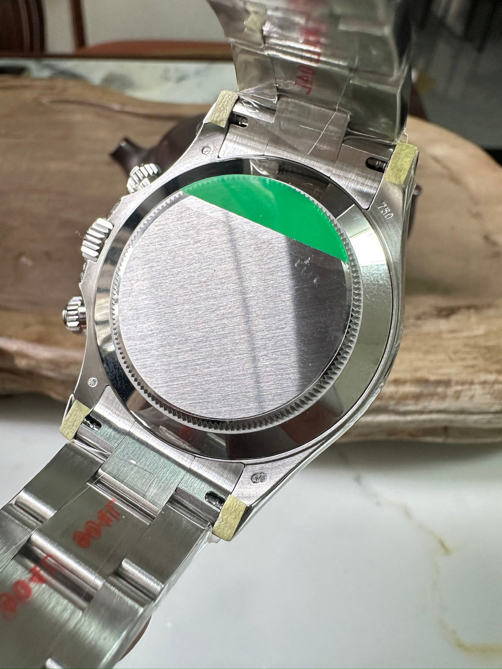 Rolex Daytona watch back view with green bezel insert, brushed metal case, crown