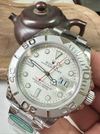 Rolex watch with silver dial, stainless steel bezel, and red second hand