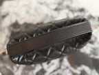 Black leather strap detail on quilted handbag
