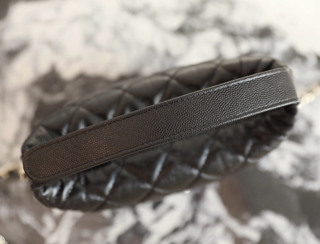 Black leather strap detail on quilted handbag