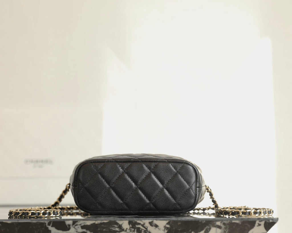 Black quilted Chanel mini handbag side view with chain strap