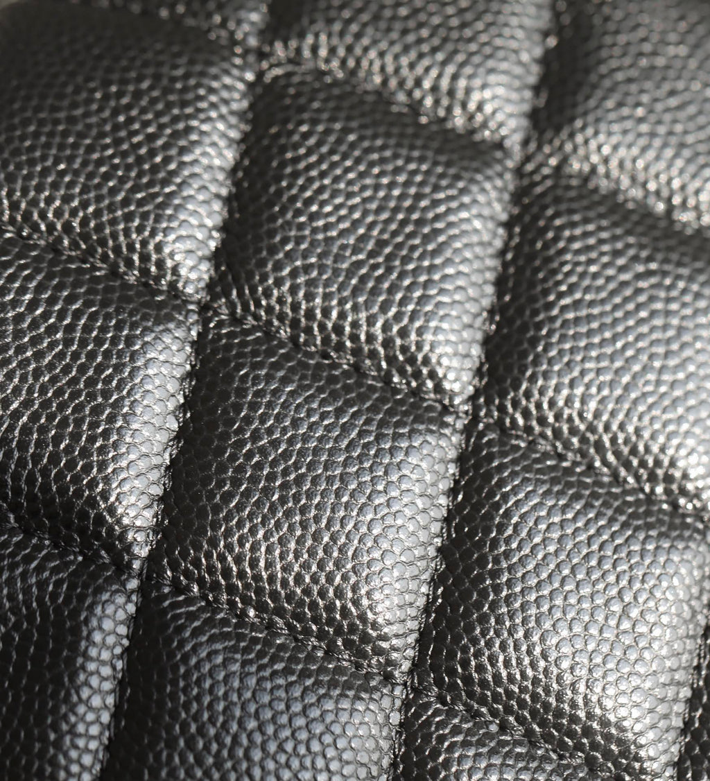 Black quilted leather close-up with diamond stitching texture