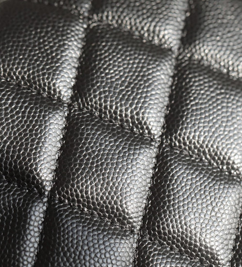 Black quilted leather close-up with diamond stitching texture