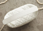 White quilted leather handbag with textured leather top handle strap