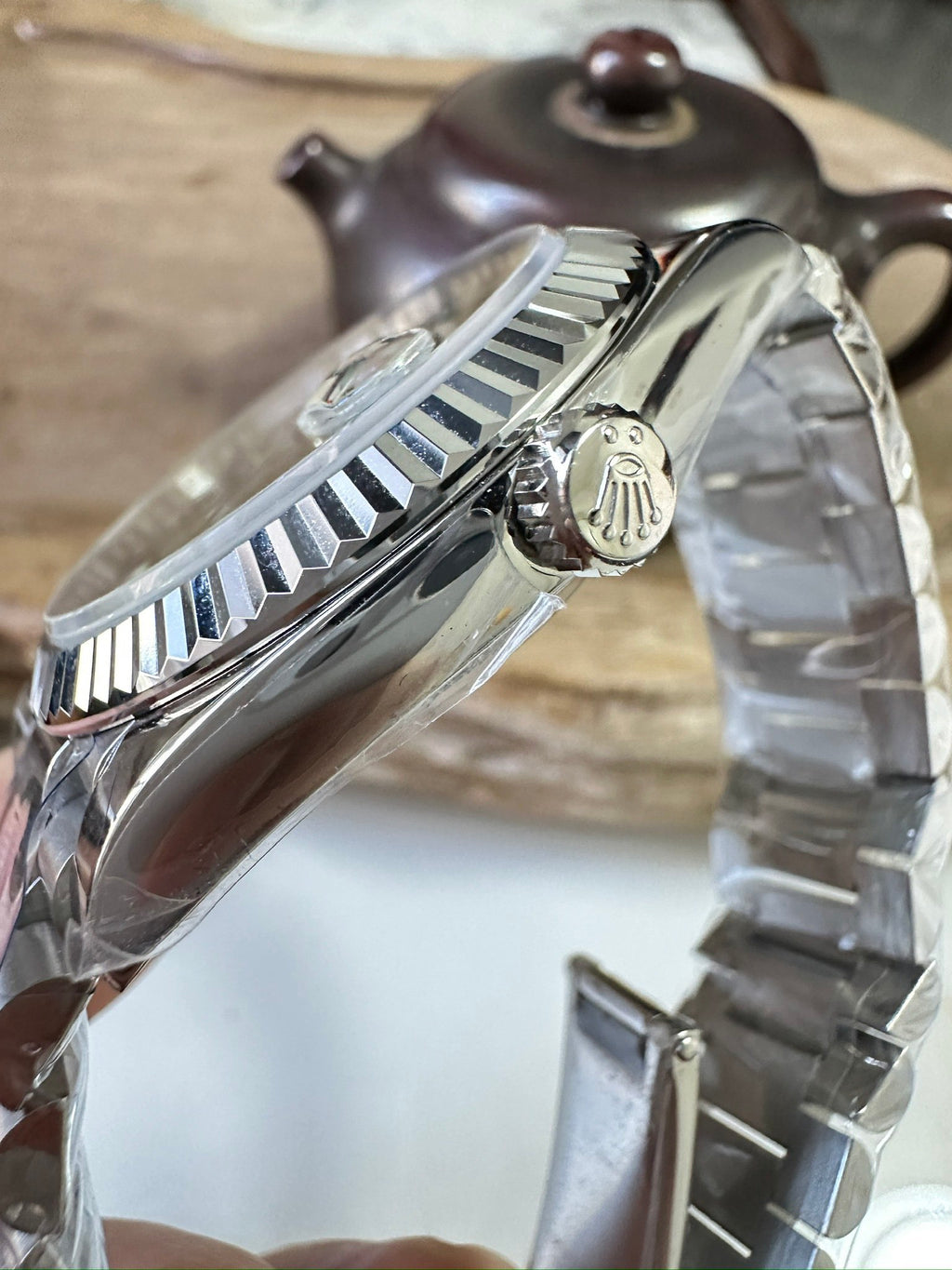 Stainless steel Rolex watch case with crown and polished bezel, side view