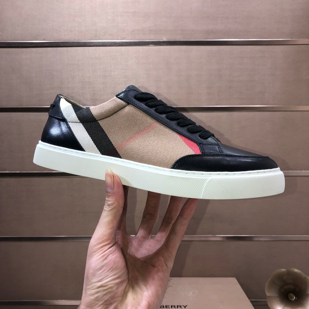 Burberry low-top sneaker held, black leather with beige panel and striped detail, white sole.