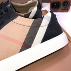 Burberry sneaker upper close-up, beige fabric with black stripe and red accent trim.