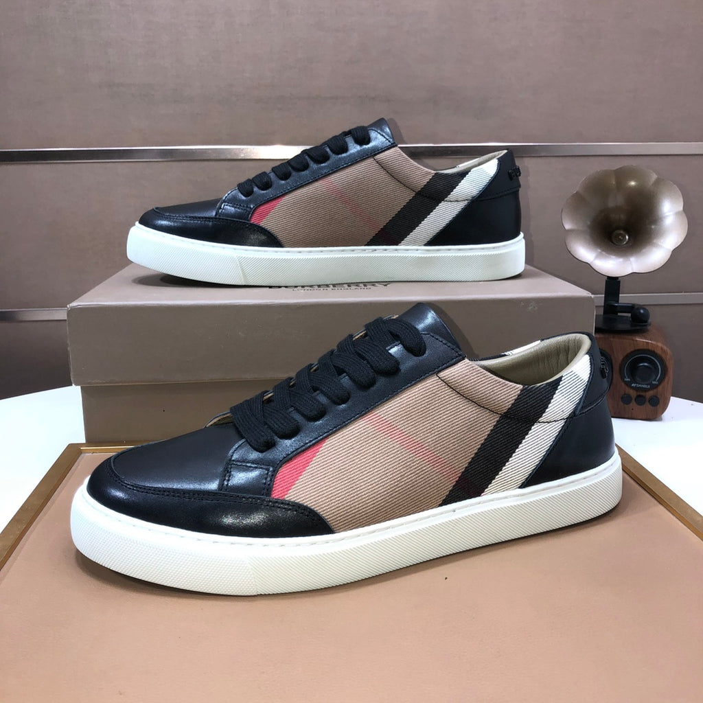 Burberry sneakers pair, black leather with beige panel, red accent stripe and white sole.