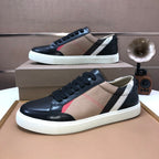 Burberry sneakers pair, black leather with beige panel, red accent stripe and white sole.