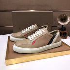 Beige low-top sneakers with white laces, black and white side stripe, red accent