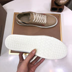 Beige sneaker outsole with tread pattern and brand text on white rubber sole