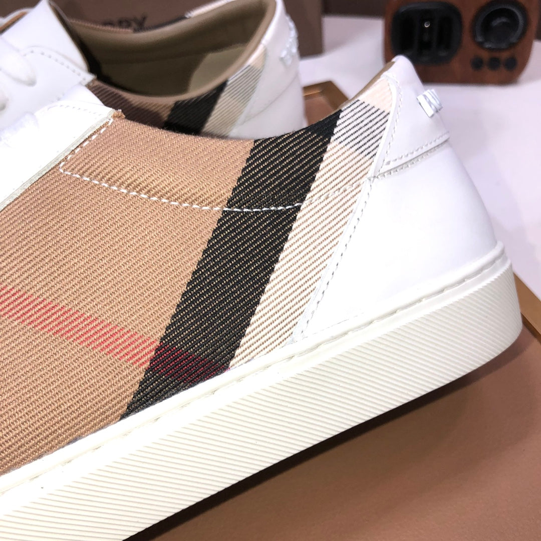 Detail of Burberry low-top sneaker side panel: tan check, black stripe, red accent