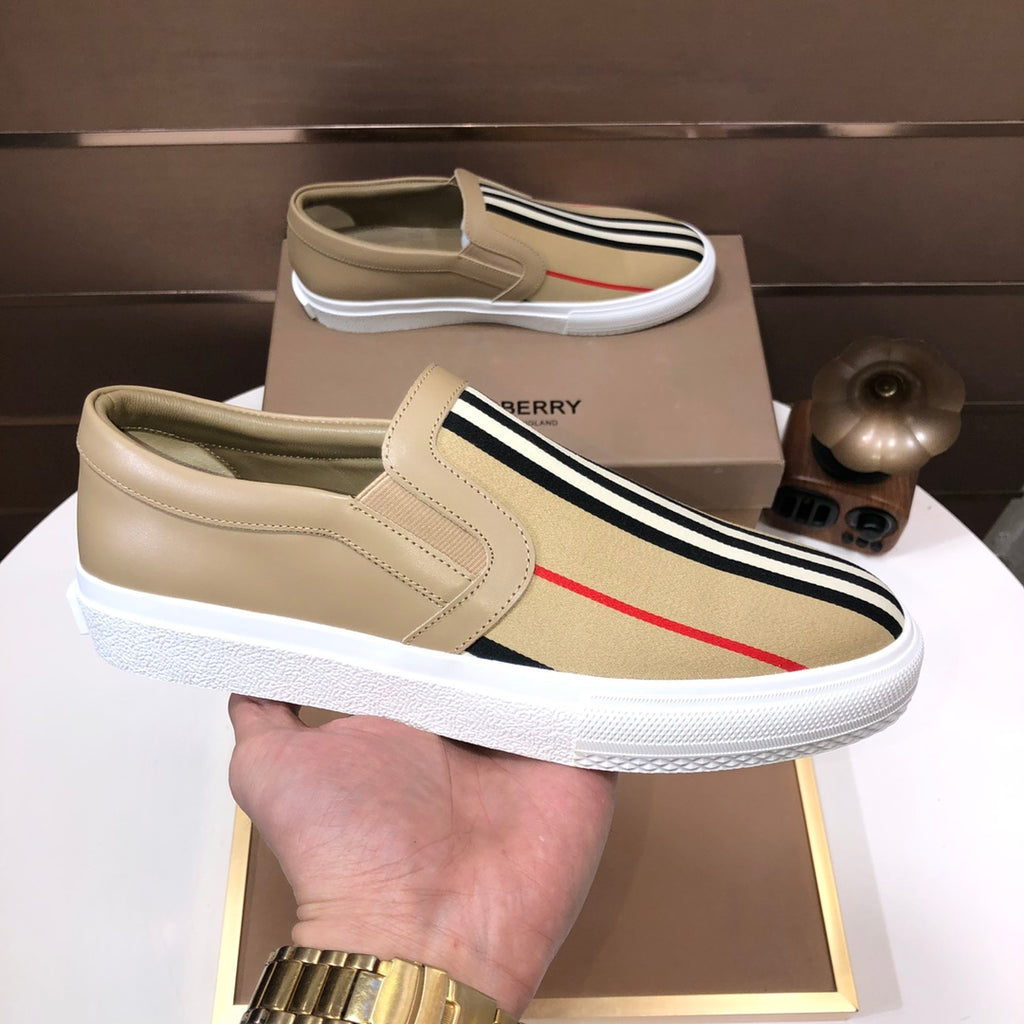 Beige slip-on sneaker with stitched upper, striped band, red stripe, white sole