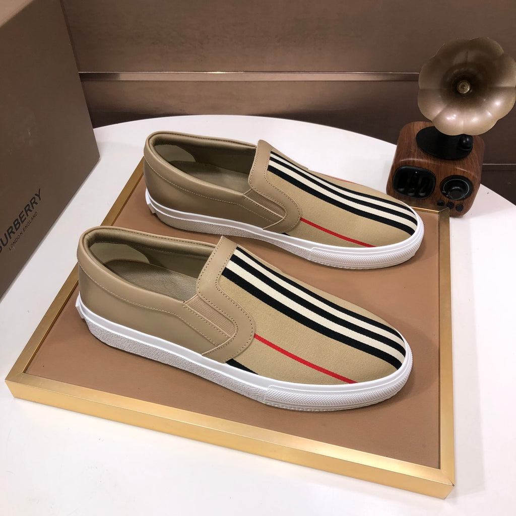 Beige slip-on sneakers with black-and-white stripe band and red accent stripe