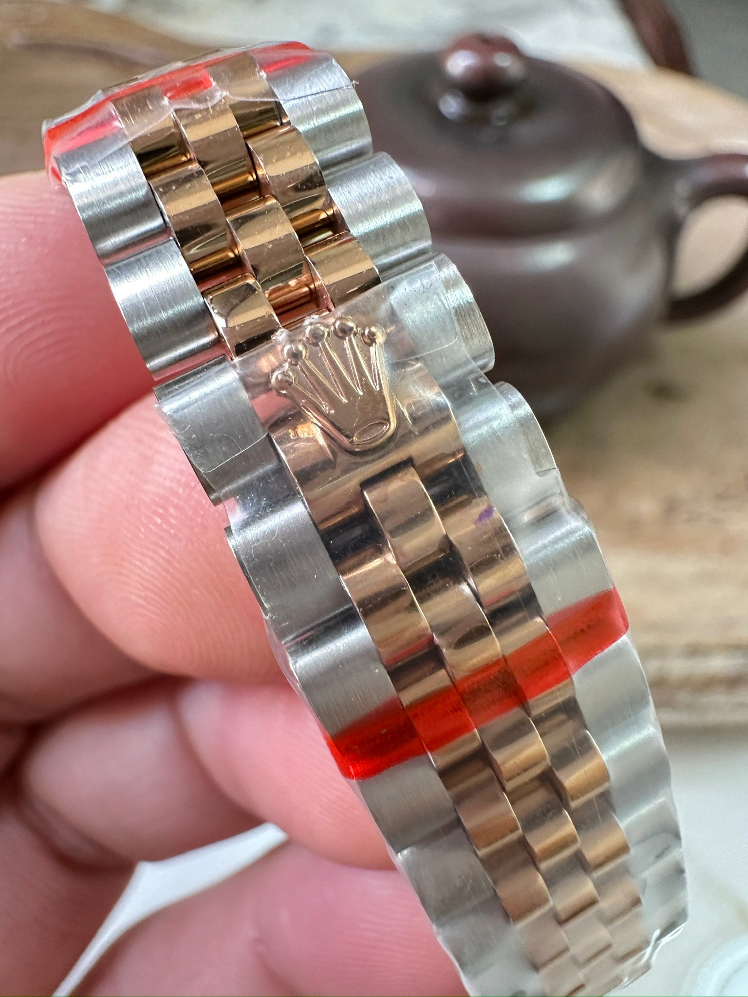 Rolex watch bracelet detail, alternating steel and gold links with clasp