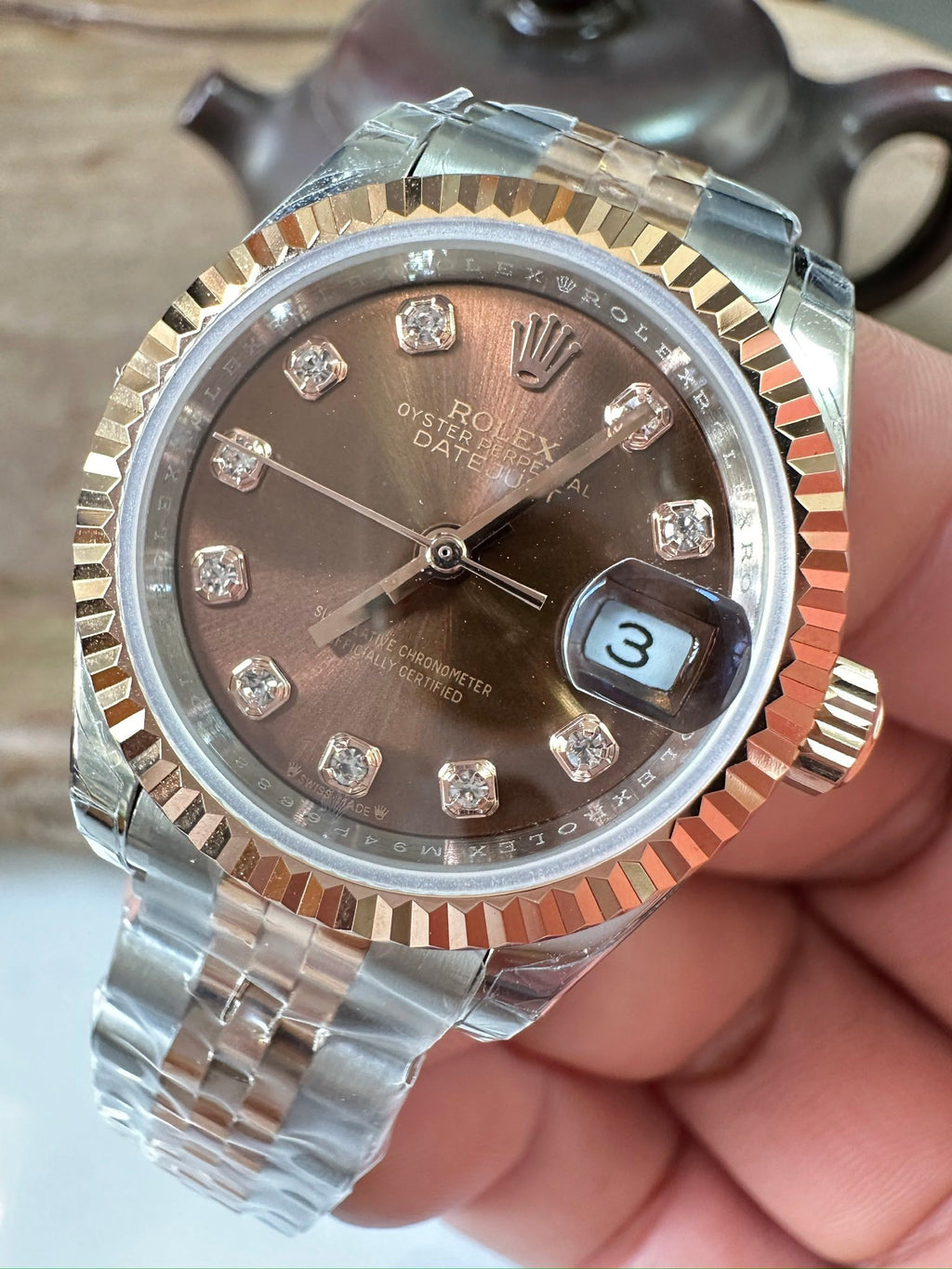 Rolex watch front view, brown diamond dial, two-tone bezel and steel/gold band