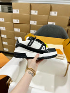 Black and white trainer sneakers with monogram strap and chunky rugged sole