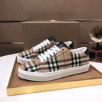 Burberry low-top sneakers pair on a box, beige plaid with white laces and black accents