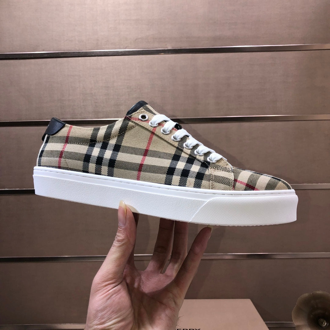 Burberry plaid low-top sneakers held in hand, white laces and white rubber sole
