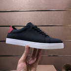Burberry dark leather sneakers held in hand, lace-up, white rubber sole