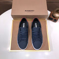 Burberry low-top sneakers, dark navy with red heel tabs and white soles.