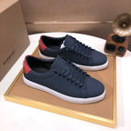Burberry lace-up sneakers, dark navy leather with red heel trim and white midsole.