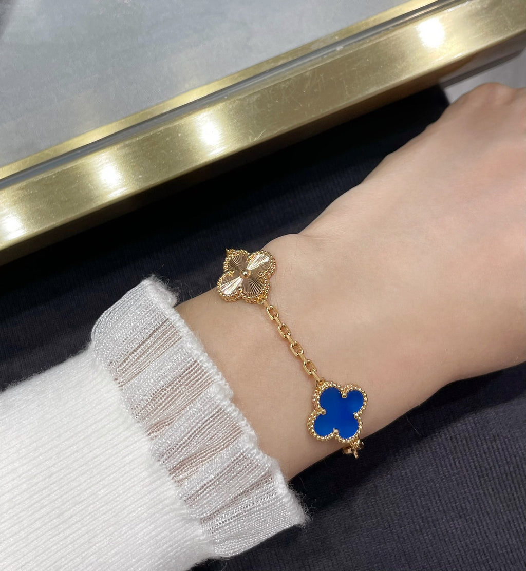 Van Cleef & Arpels gold clover bracelet with blue enamel motif and small bow charm