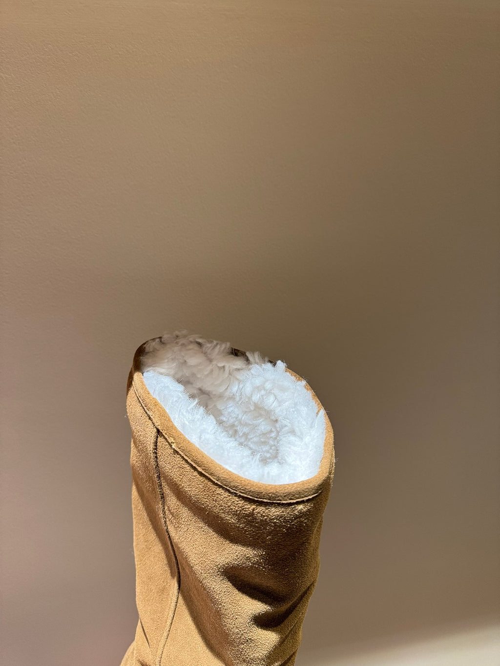 Tan suede knee-high boot with shearling lining, open-top view