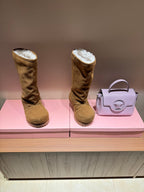Pair of tan knee-high suede boots with shearling lining and chunky ridged soles