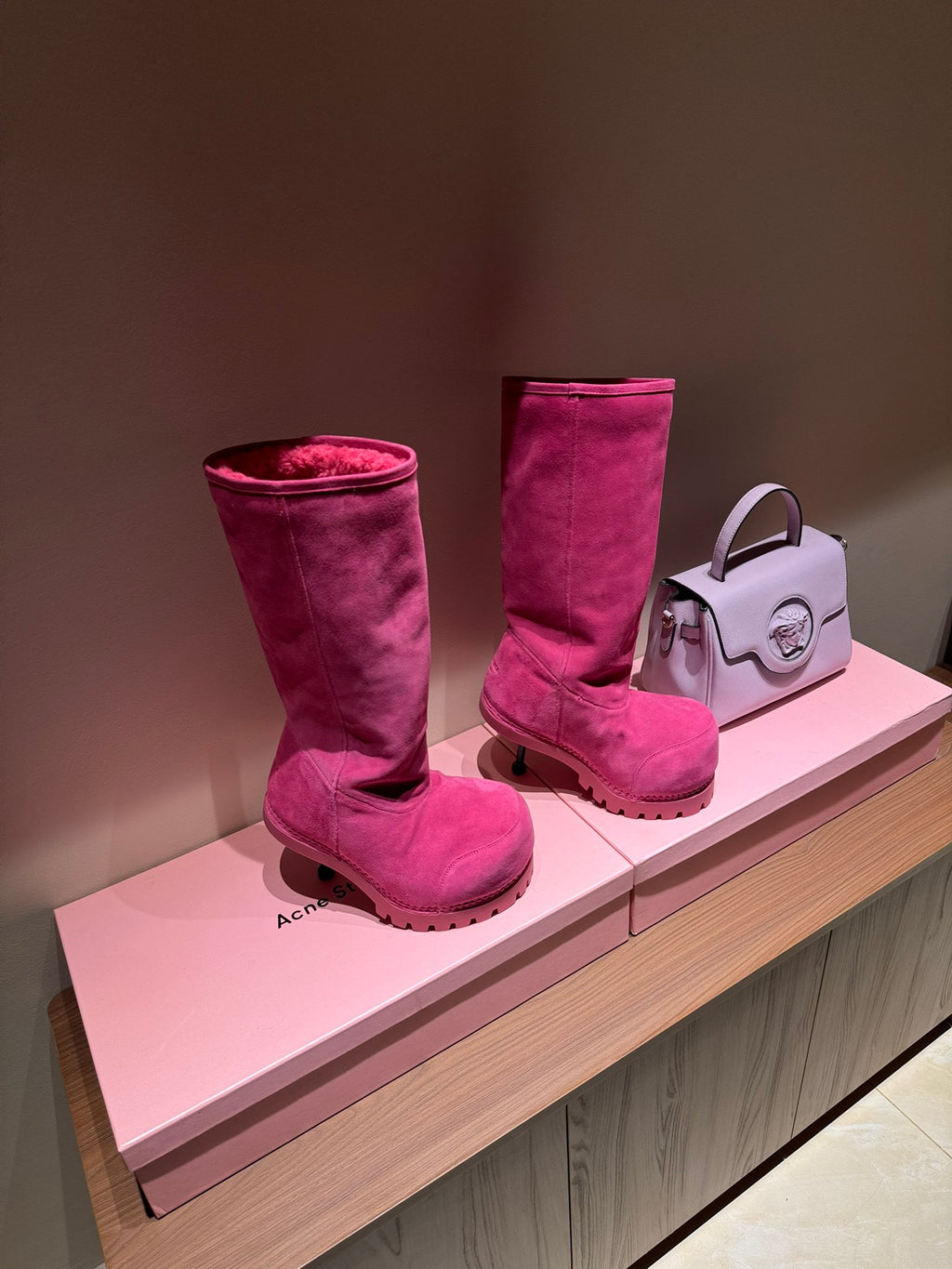 Women's Balenciaga magenta suede boots on display, tall shaft with shearling lining
