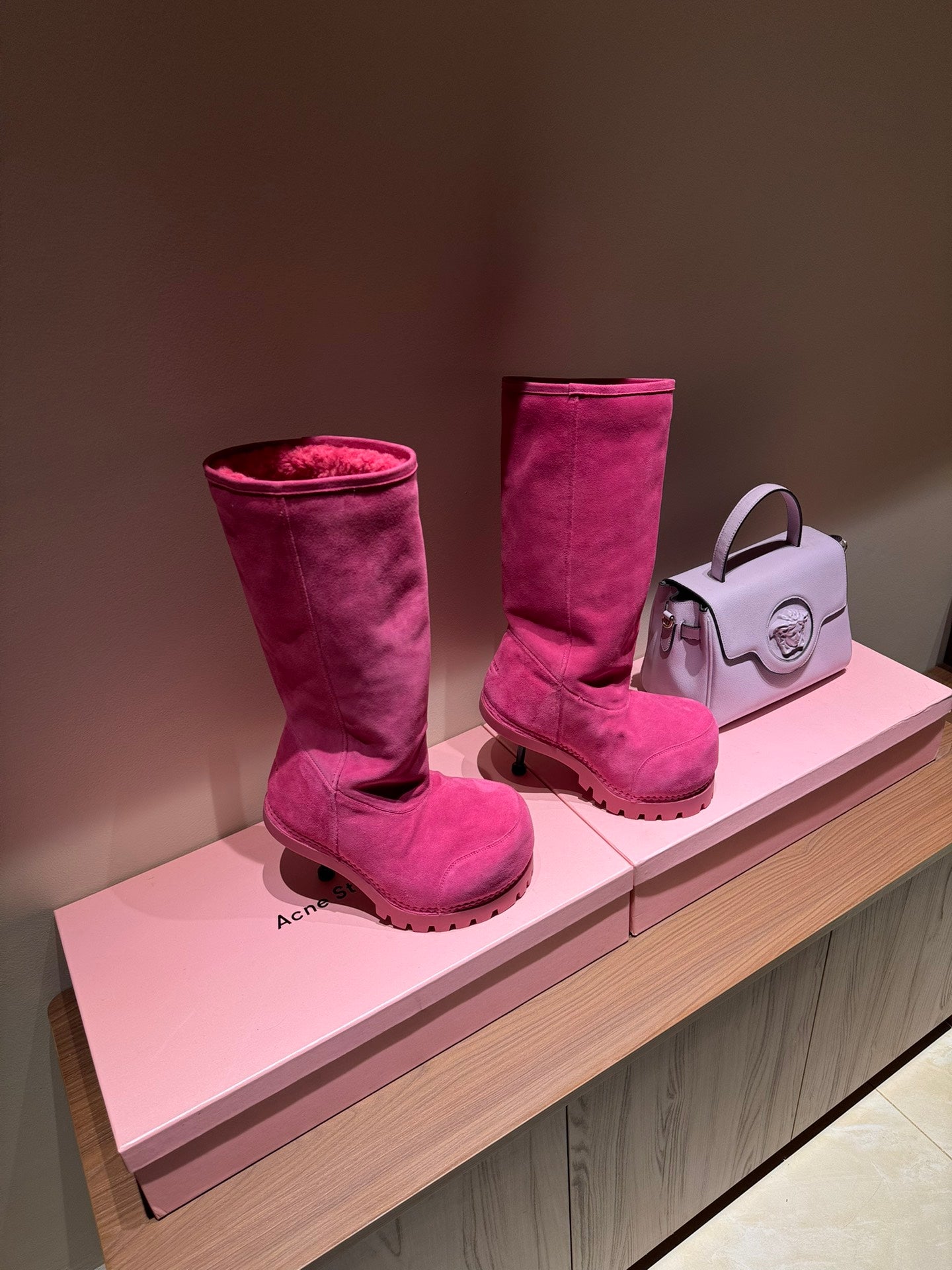 Women's Balenciaga magenta suede boots on display, tall shaft with shearling lining
